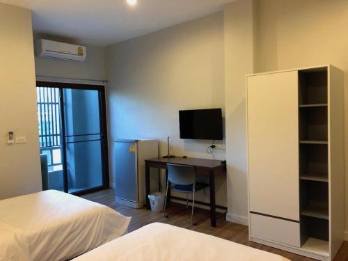 a bedroom with a desk with a computer and a tv at Pawa Place (By Inpawa) in Ban Phai