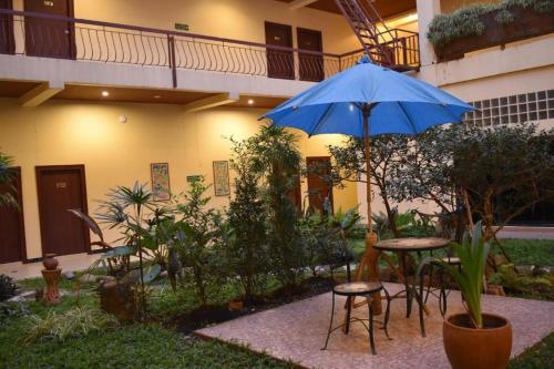 patio con tavolo e ombrellone blu di King Hotel a Loei