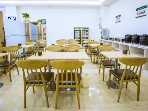 a row of tables and chairs in a room at GreenTree Inn Heze Shan County Huxi South Road Express Hotel in Heze