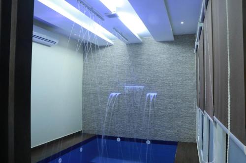 a bathroom with a shower with blue tiles at D in Al Ḩamrāʼ