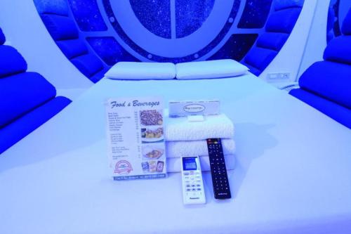 a seat in a plane with a remote control and a box of food at Astrotel Avenida in Manila