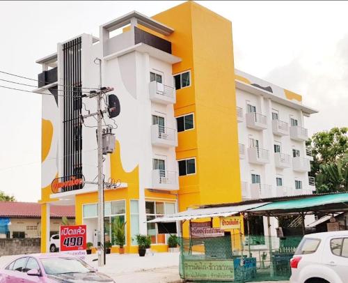 a large yellow and white building on a city street at Wangmaewmeo in Ban Nong Sanom
