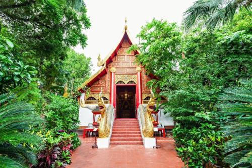 a small nepalese temple with stairs leading to the door at Tonkok Hotel in Chiang Rai