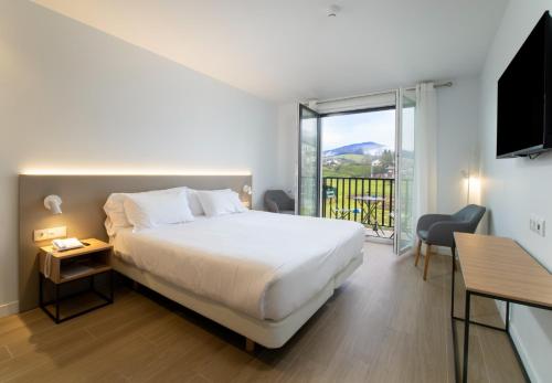 Pokój hotelowy z łóżkiem i balkonem w obiekcie Hotel Trinkete w mieście Elizondo