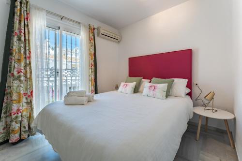 a bedroom with a large bed with a large window at La Cala Mijas Playa Club in La Cala de Mijas