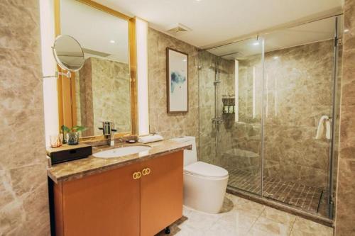 a bathroom with a shower and a sink and a toilet at Bati Holiday Hotel in Zhongshan