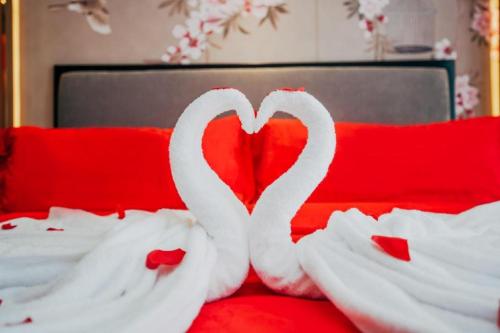 two white swans forming a heart on a bed at Bati Holiday Hotel in Zhongshan