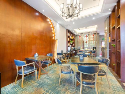 義烏市にあるJIAN AI XI YUE HOTELの木製の壁と青い椅子とテーブルが備わるレストラン