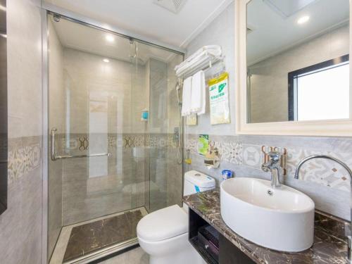 a bathroom with a toilet and a sink and a shower at JIAN AI XI YUE HOTEL in Yiwu