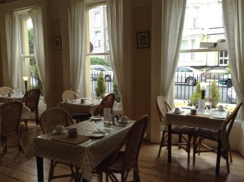 a dining room with tables and chairs and a window at Citadel House Hotel in Plymouth