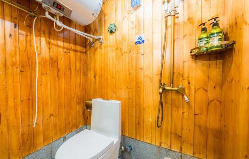a wooden bathroom with a toilet and a shower at The Courtyard Suzhou Inn Hemu Branch in Suzhou