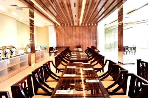 een lange eetkamer met een lange tafel en stoelen bij Grand Metro Hotel Tasikmalaya in Tasikmalaya