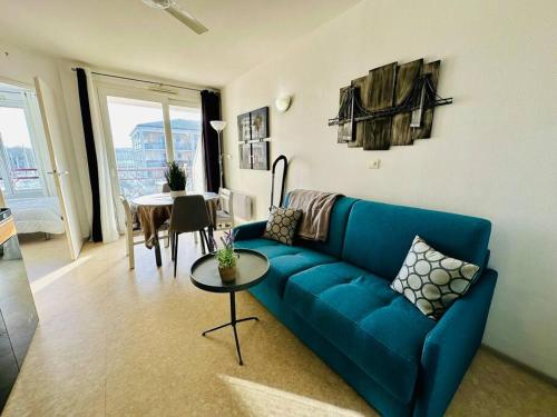 uma sala de estar com um sofá azul e uma mesa em Port Bougainville em Rochefort