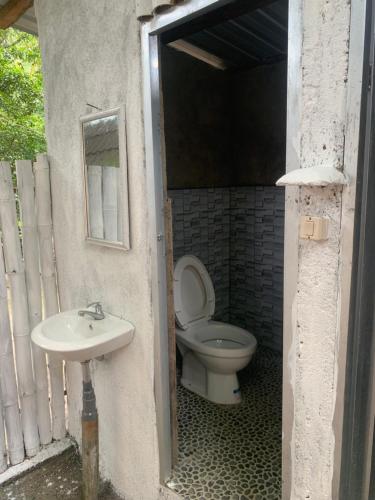 a bathroom with a toilet and a sink at Tiu Ronton River , Bungalows Camping and Trekking in Pawenang