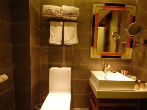 uma casa de banho com um lavatório, um WC e um espelho. em James Joyce Coffetel Lushan Scenic Spot Guling Street Branch em Haihui