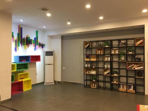 a room with a large wall with colorful items at 7Days Inn Shenzhen Longgang Nanlian Metro Station Branch in Longgang