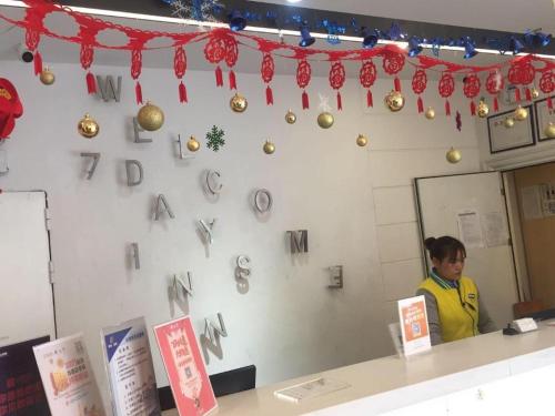 a man standing behind a counter with christmas ornaments at 7Days Inn Shenzhen Longgang Nanlian Metro Station Branch in Longgang