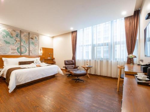 1 dormitorio con 1 cama, 1 silla y 1 ventana en James Joyce Coffetel Bengbu Yintai City Branch, en Bengbu