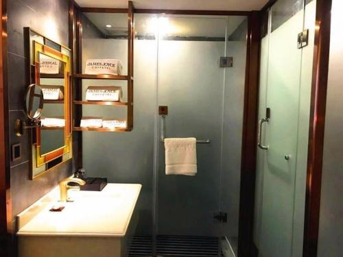 y baño con ducha, lavabo y espejo. en James Joyce Coffetel Bengbu Yintai City Branch, en Bengbu