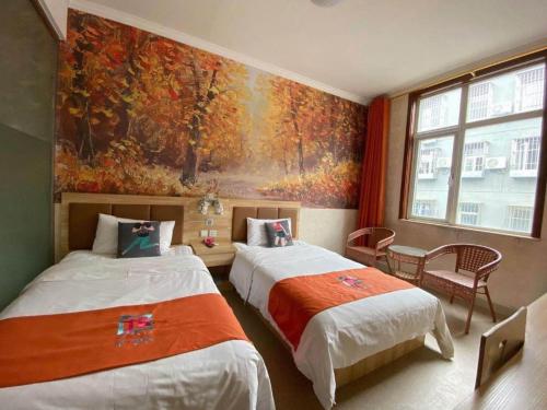 two beds in a room with a painting on the wall at PAI Hotel Beijing Capital International Airport Linhe Development Zone in Tahe