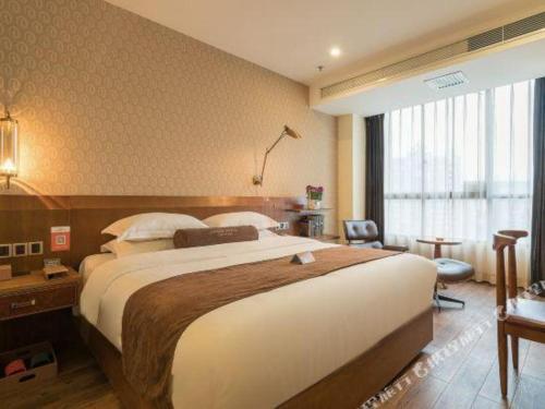 ein Schlafzimmer mit einem großen Bett in einem Hotelzimmer in der Unterkunft James Joyce Coffetel Xishuangbanna Poshui Square Manjinglan Ancient City in Jinghong