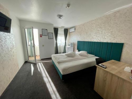 een slaapkamer met een bed met een groen hoofdeinde bij Academia De Arhitectura in Piteşti