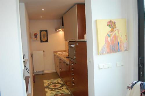 a kitchen with a painting of a woman on the wall at Bvba Bacana in Rotselaar