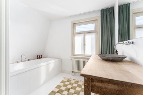 a bathroom with a wooden counter with a sink at Magique 31 - Luxeverblijf met tuin & parking in Oostduinkerke