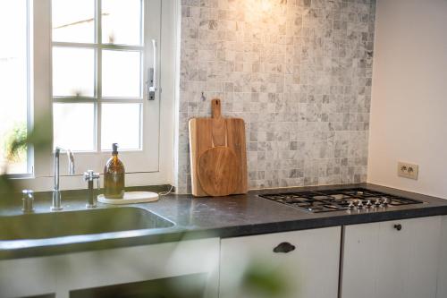 a kitchen with a counter top with a stove top oven at Magique 31 - Luxeverblijf met tuin & parking in Oostduinkerke