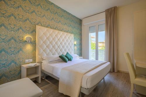 a bedroom with a large bed and a window at Hotel Acquamarina in Bellaria-Igea Marina