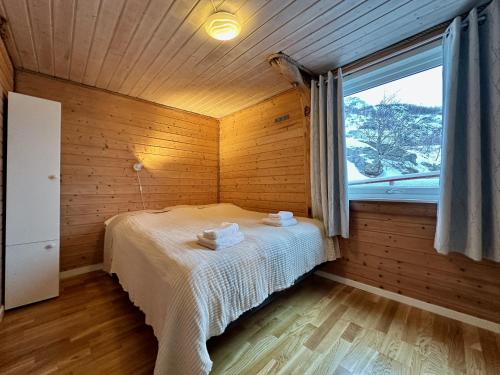 1 dormitorio con 1 cama en una habitación con ventana en Lofoten Troll Point, en Bøstad