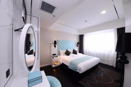 YufaにあるXana Lite Hotel Beijing Daxing International Airportのベッドルーム(ベッド1台、大きな鏡付)