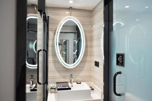 a bathroom with a sink and a mirror at Xana Lite Hotel Beijing Daxing International Airport in Yufa