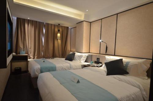 a hotel room with two beds and a television at Xana Lite Ganzi Luding YanAn Road in Lutingkiao