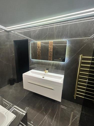 a bathroom with a white sink and a mirror at Large Modern Family Home in Murrayfield - Very close to City Centre - 10 mins by Direct Bus - Private Driveway & Garden in Edinburgh