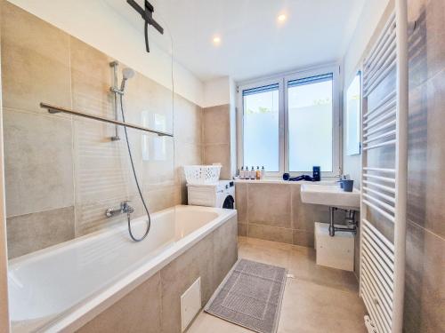 La salle de bains est pourvue d'une baignoire et d'un lavabo. dans l'établissement FeelHome-Donau-6 Gäste-WiFi-Smart TV, à Vienne