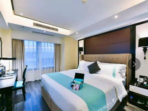 Heshan的住宿－Xana Hotelle Xiamen Airport Zone Government，一间卧室配有一张带书桌的床和一台笔记本电脑。