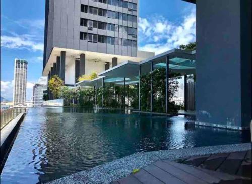 a swimming pool in front of a building at Tropicana 218 Macalister #Seaview #Modern Retro #Infinity Pool #Georgetown #7pax #3BR 2bath #1King 2Queen 1Single #Quality well maintained #Private host in George Town