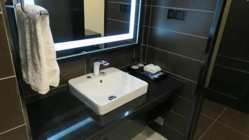 ein Bad mit einem Waschbecken und einem Spiegel in der Unterkunft Xana Hotelle Yinchuan Dayuecheng Branch in Yinchuan
