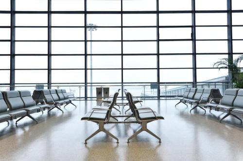 uma grande sala com cadeiras e mesas num aeroporto em JI Hotel Shanghai Hongqiao Transport Hub Jiuting em Xangai