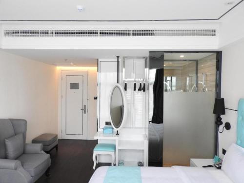ein Schlafzimmer mit einem Bett und ein Badezimmer mit einem Spiegel in der Unterkunft Xana Hotelle Ankang High-Tech High School in Ankang