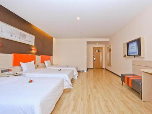 a hotel room with two beds and a flat screen tv at 7 Days Premium Jinan Gaoxin Qu Wanda Plaza in Hongjialou