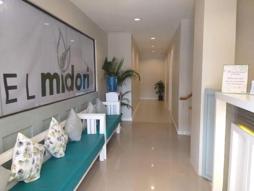 - un couloir avec un banc bleu et des oreillers dans l'établissement Hotel Midori Davao, à Davao