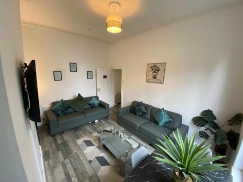 a living room with two couches and a tv at Huge Home With Street Parking in Liverpool