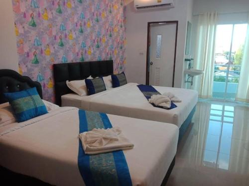 2 łóżka w pokoju hotelowym z ręcznikami w obiekcie The Linux Garden Hotel (City Amphur Muang Yala) w mieście Yala