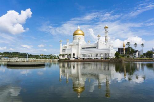 a large white mosque with a gold dome on top at Grand City Hotel in Kampong Gadong