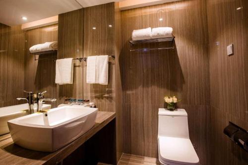 La salle de bains est pourvue d'un lavabo blanc et de toilettes. dans l'établissement Fortune Hotel Ningde, à Ningde