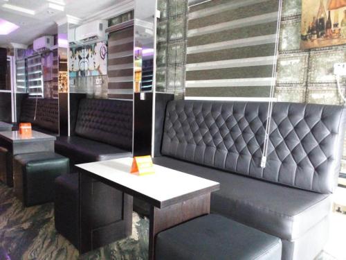 un bar con asientos negros y una mesa. en Euro Lounge and Suites, en Adegbite