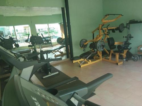 um ginásio com várias máquinas de piso e um espelho em Neocourts Hotel em Enugu