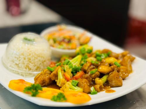 a plate of food with rice and chicken and vegetables at Hotel River Front in Tissamaharama